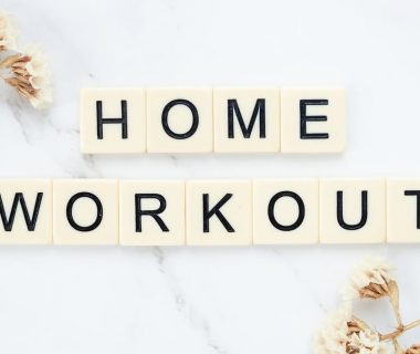 Stylish letter tiles spelling 'Home Workout' on a clean marble background with floral accents.